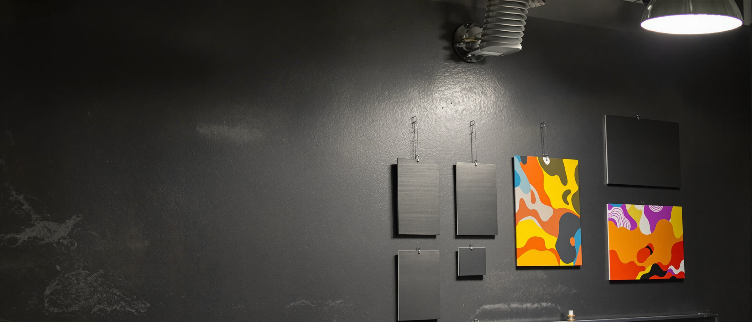 Finished metal panels stacked on a dark steel bench, the top panel carrying a full-color printed graphic while the sheets beneath it stay raw gray aluminum.
